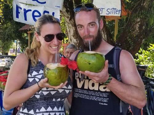 Glückliche Praktikanten trinken aus einer Kokosnuss