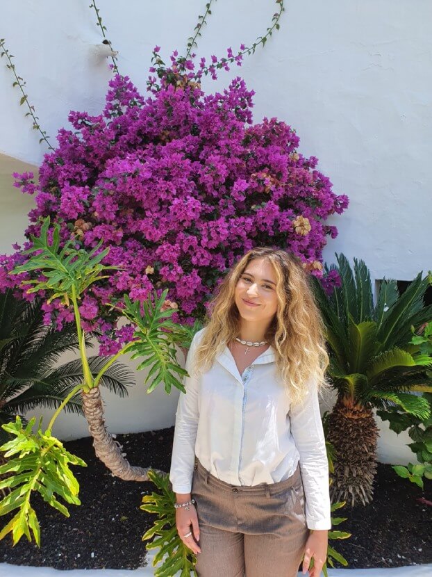 Intern in front of the hibiscus plant Intern in front of the hibiscus plant