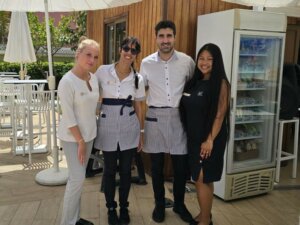 Deux stagiaires prennent une photo avec leurs collègues de travail pendant leur stage en hôtellerie à l'étranger.