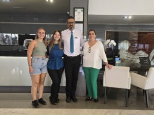 Deux stagiaires prennent une photo avec deux collègues pendant leur stage en hôtellerie à l'étranger.