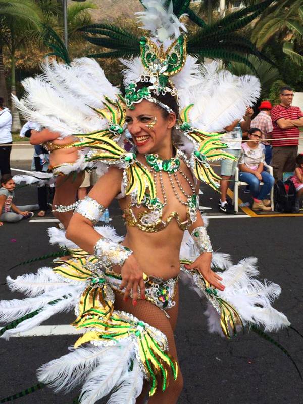 Crowds and performers celebrating at the vibrant carnival parade in the Canary Islands.