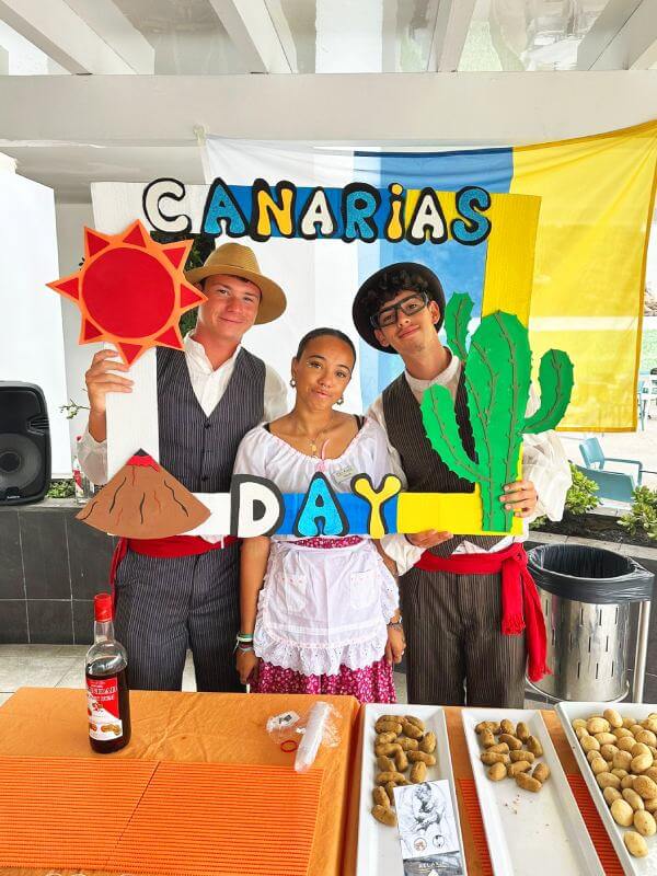 Interns smiling and enjoying their workday while celebrating Canary Islands Day in a festive atmosphere.