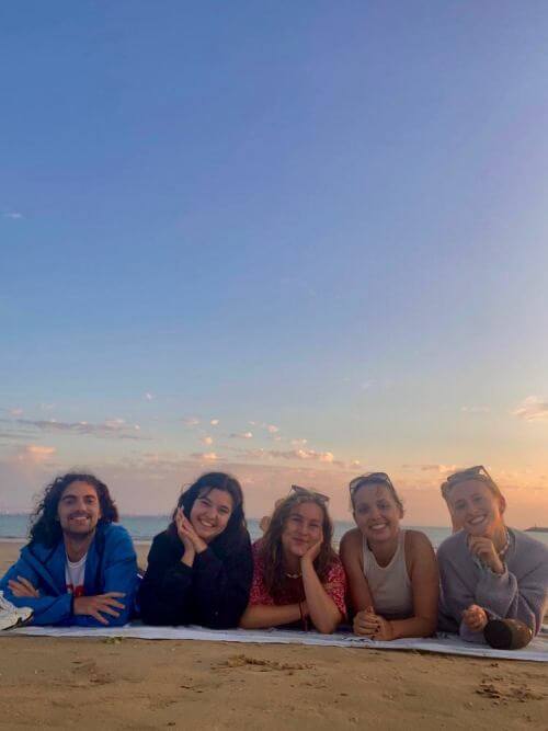 Los estudiantes se relajan después del trabajo en la playa Practicantes disfrutando de Playa Amadores con amigos después del trabajo durante su práctica en Gran Canaria.