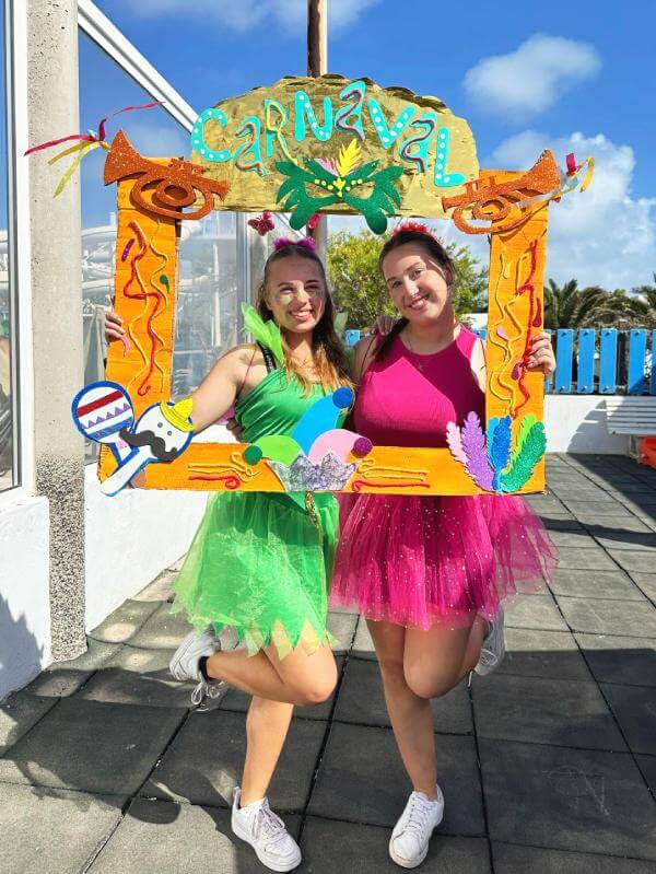 Zwei S-W-E-P Praktikantinnen im Karneval-Fieber Zwei S-W-E-P Praktikantinnen in festlicher Stimmung beim Karneval mit bunten Accessoires und fröhlichen Gesichtern während ihrer Praktika auf den Kanarischen Inseln