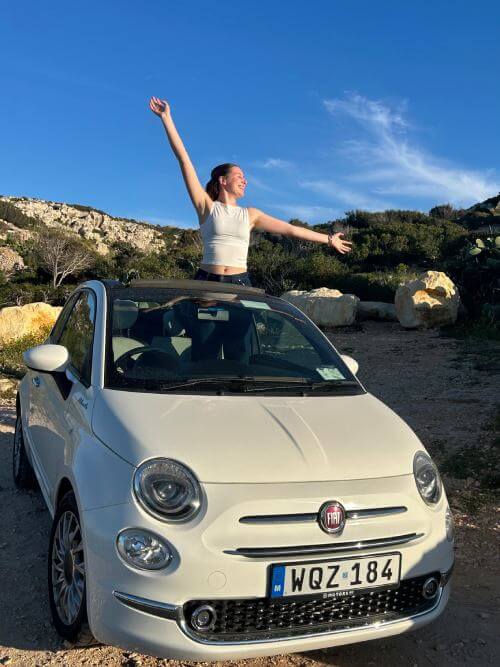 Le stagiaire part en voyage sur la route Une stagiaire sur le toit d’une voiture lors d’un road trip en solo pendant son stage.