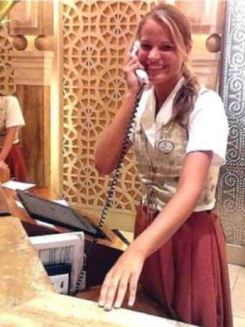 Un stagiaire qui s’amuse au travail Stagiaire réceptionniste souriante répondant à un appel téléphonique