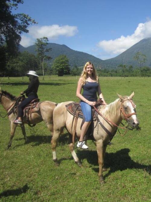 Un stagiaire qui se crée des souvenirs inoubliables Stagiaire souriante assise sur un cheval lors d’une expérience en plein air mémorable