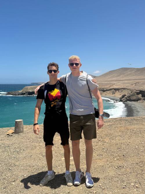 Two interns standing side by side, smiling and looking at the camera during their internship