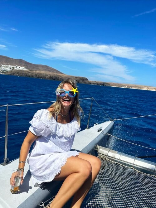 Smiling intern wearing funny glasses during a boat tour on her internship in Tenerife.