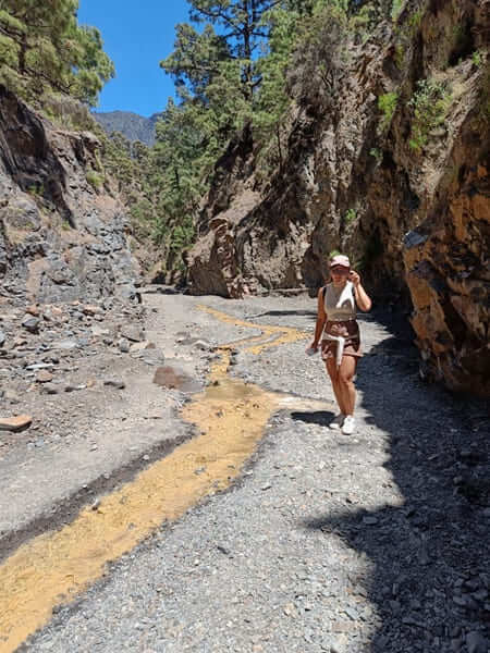 Trekking vicino alla Cascata de Colores a La Palma Tirocinante che cammina in un canyon vulcanico roccioso vicino alla Cascata de Colores a La Palma.